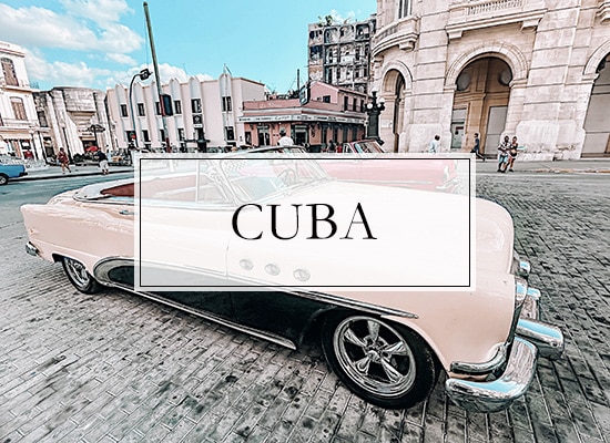 2 pink classic cars in the main square of Havana Cuba with the word Cuba on top of the photo